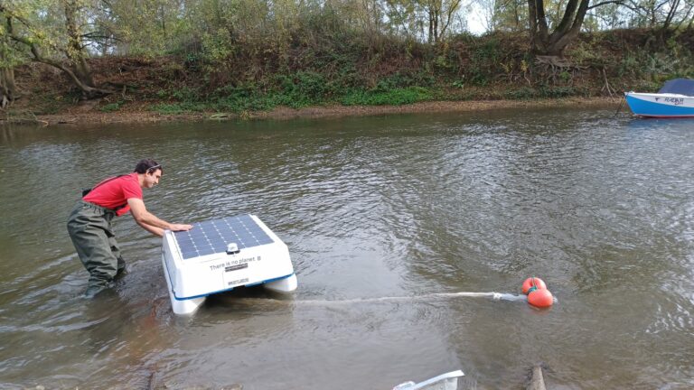 homme dans une rivière avec un robot ramassant des microplastiques