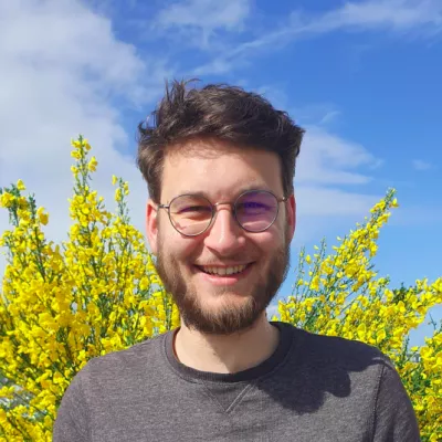 Photo portrait de Valérian, debout devant une plante jaune